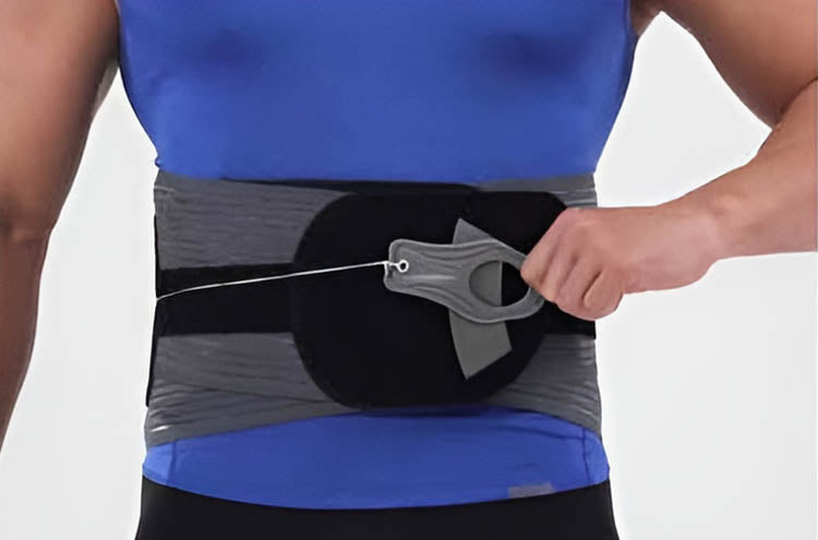 The Neurogena back support belt being tightened with one hand